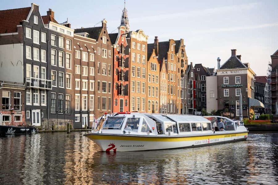 Amsterdam: City Centre Canal Cruise & Free Flower Cocktail - Amsterdam from the water, with a sweet drink in hand