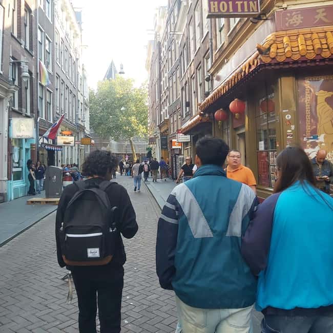 Amsterdam: Spanish Tour Unmasking the Redlight District - Warmoesstraat and a tucked-away stop